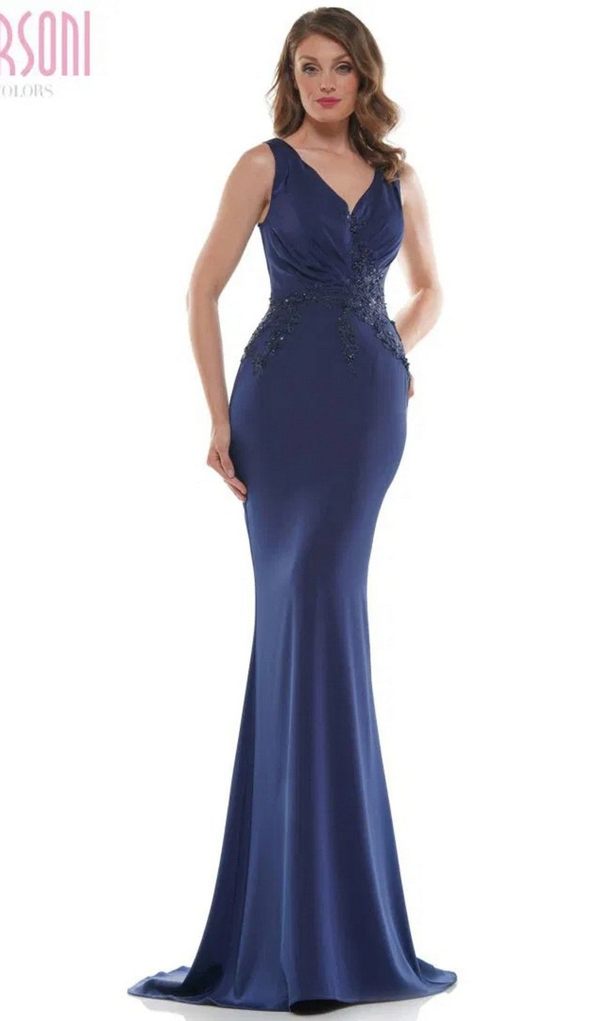 A woman models the Marsoni MV1054 long formal dress in navy, featuring a sleeveless trumpet silhouette and subtle embellishments at the waist and hips, standing against a plain white background.